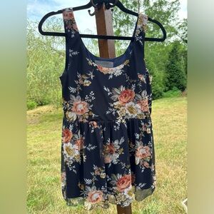 Floral pattern on a navy background sleeveless shirt sold by Sundance catalogue.